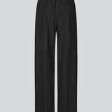 Black trousers with wide legs and pleats. The Ridermd pants feature side pockets and an elastic waistband – sleek and comfortable at the same time.