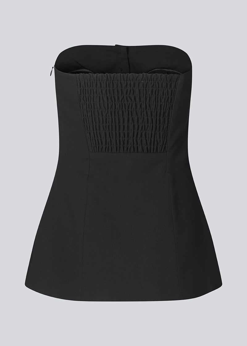 Black corset top with button details. The Ridermd top features a smocked back and invisible zipper – a flattering and timeless piece.