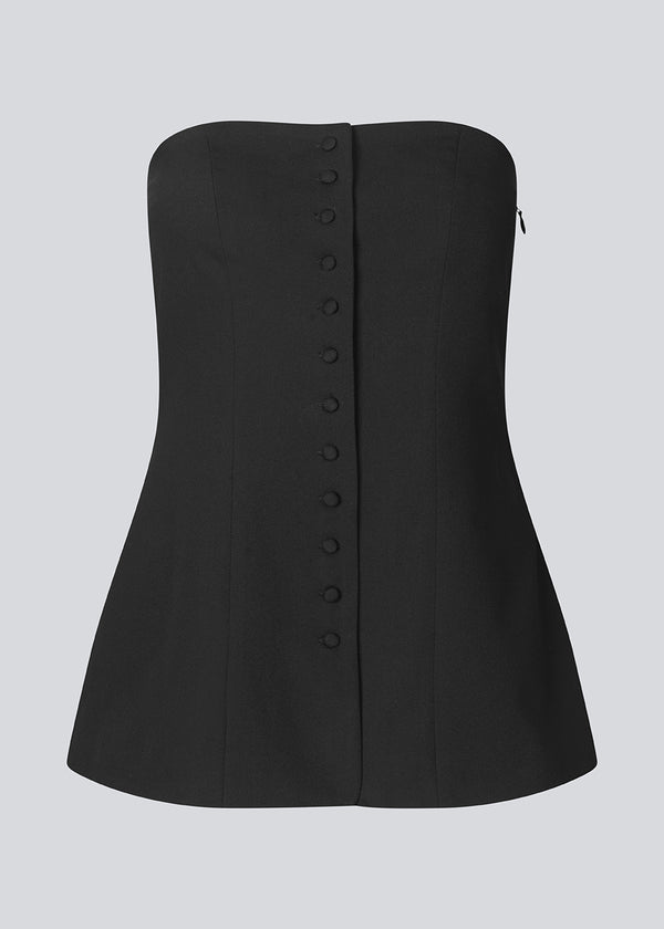 Black corset top with button details. The Ridermd top features a smocked back and invisible zipper – a flattering and timeless piece.