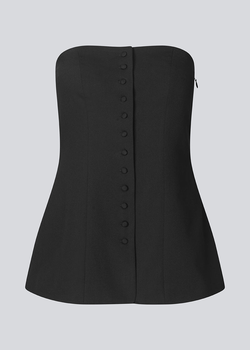 Black corset top with button details. The Ridermd top features a smocked back and invisible zipper – a flattering and timeless piece.