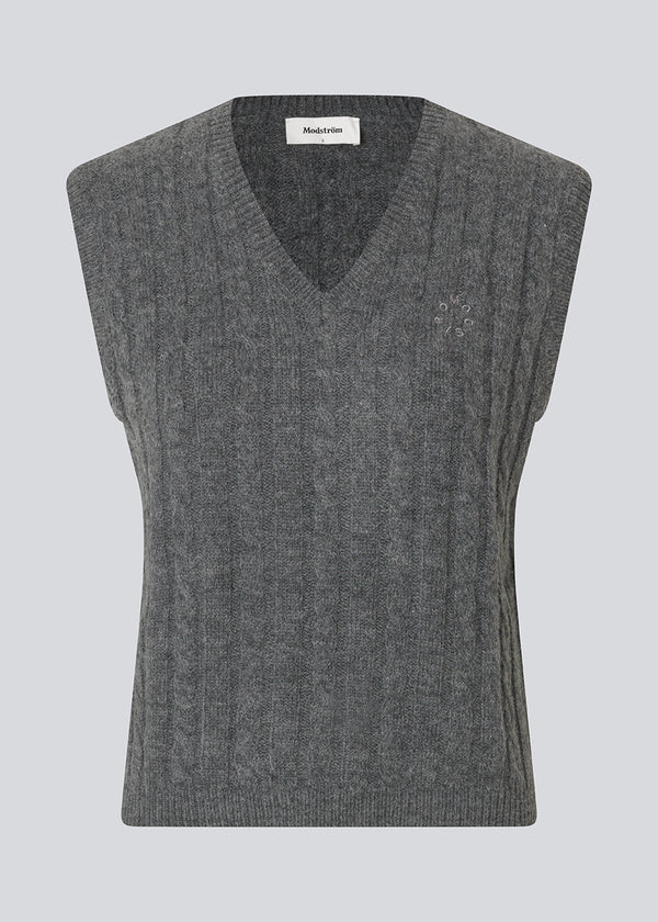 Fitted cable knit vest. The Risemd Vest features a timeless cable knit design and an embroidered logo on the chest – perfect for a cool, classic layered look.
