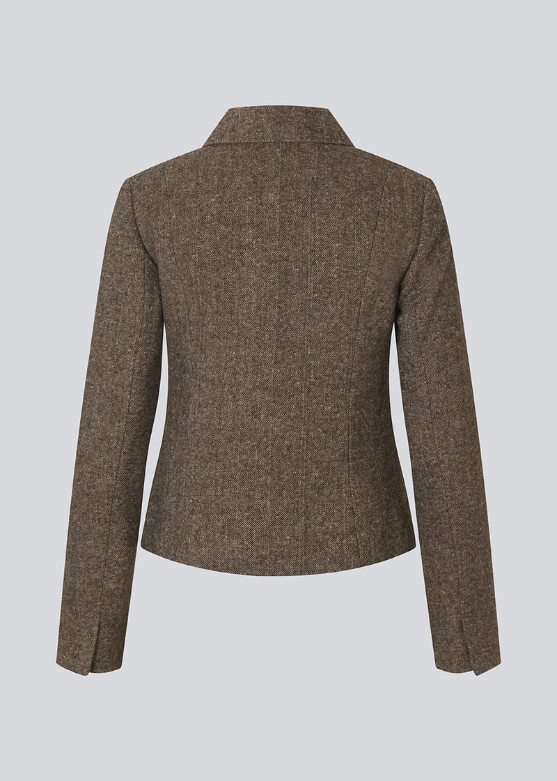 Kort firgursyet blazer i uld. Rockymd blazer har knappelukning, to skrålommer og klassisk udstryk , der gør den nem at style.
