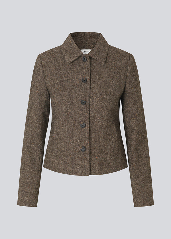 Kort firgursyet blazer i uld. Rockymd blazer har knappelukning, to skrålommer og klassisk udstryk , der gør den nem at style.