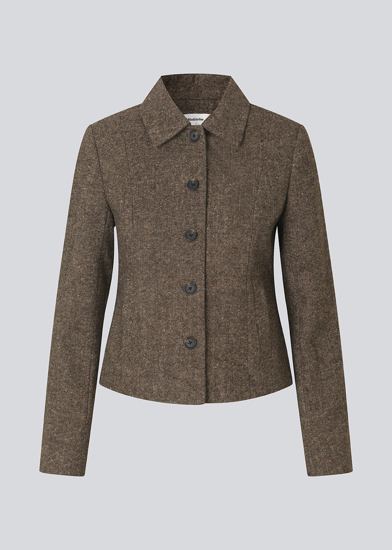 Kort firgursyet blazer i uld. Rockymd blazer har knappelukning, to skrålommer og klassisk udstryk , der gør den nem at style.
