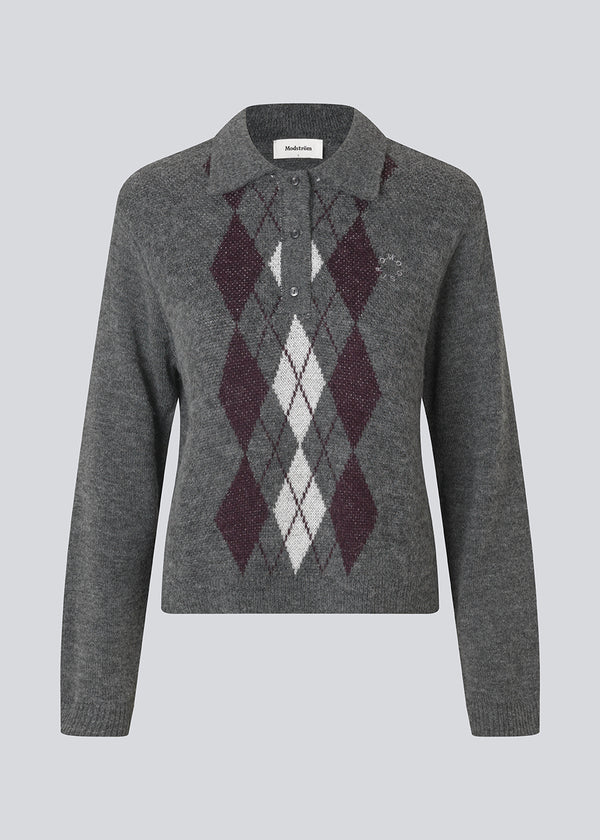 Polo inspired knit with long sleeves. The Roganmd polo knit features a harlequin pattern and an embroidered chest logo – giving it a classic and playful look.
