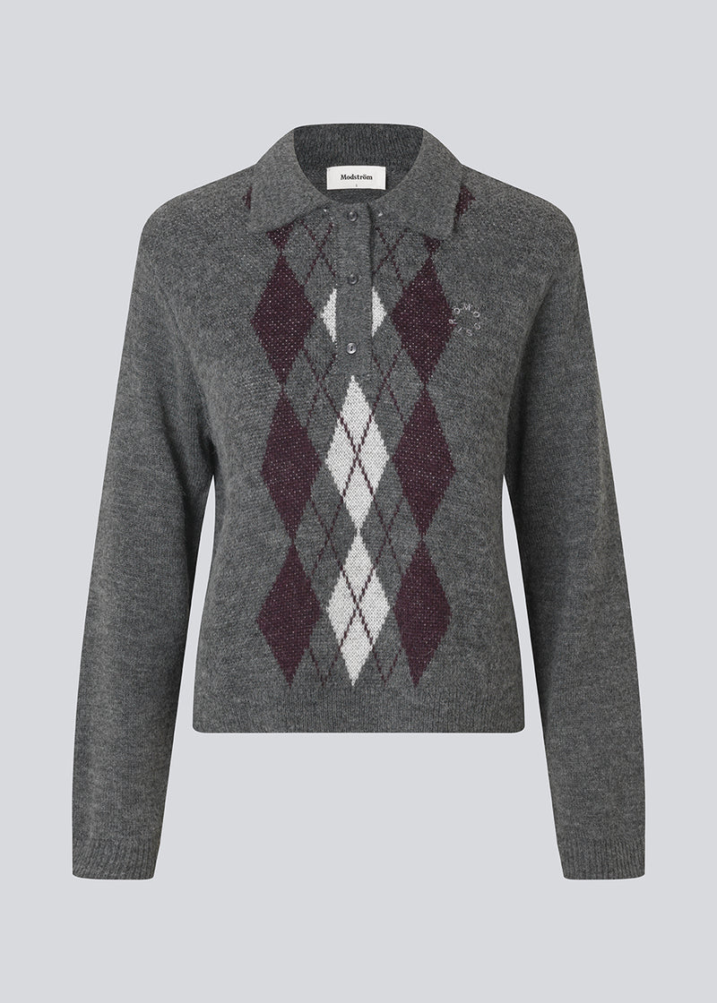 Polo inspired knit with long sleeves. The Roganmd polo knit features a harlequin pattern and an embroidered chest logo – giving it a classic and playful look.