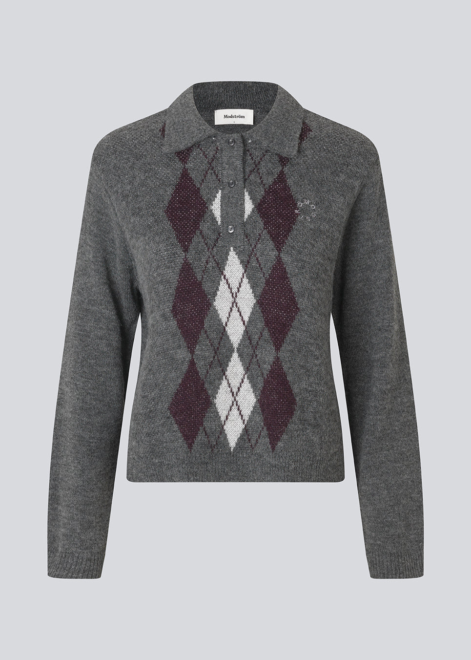 Polo inspired knit with long sleeves. The Roganmd polo knit features a harlequin pattern and an embroidered chest logo – giving it a classic and playful look.