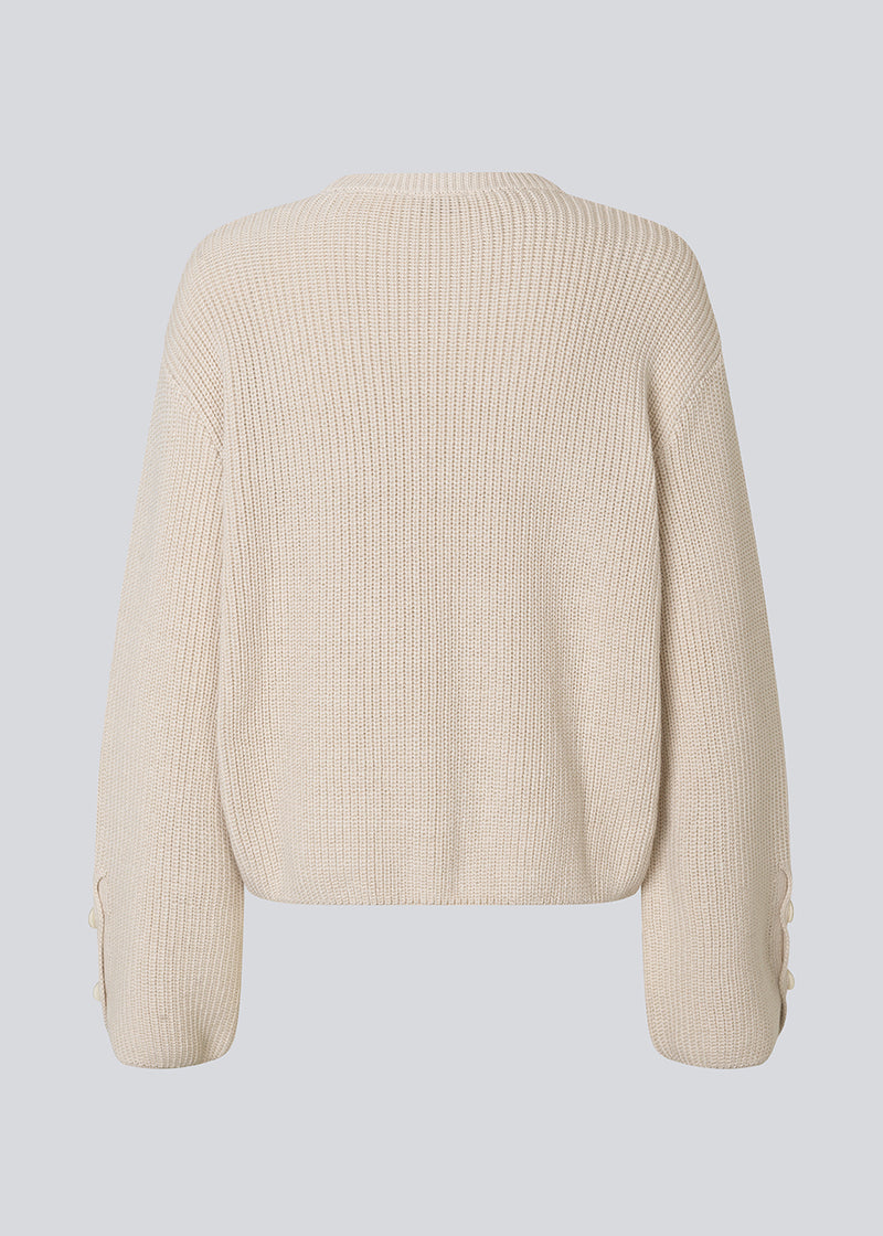 Knitted sweater in white/cream in organic cotton. The Rosemd o-neck features a round neckline and button details on the sleeves – a simple and classic style.