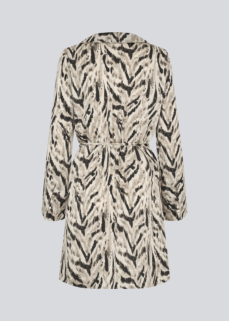 Printed shirt dress in 100% recycled polyester with collar, V-neck and button closure. The Saber-limbed Print Dress has a tie at the waist and a knee length for a flattering cut.
