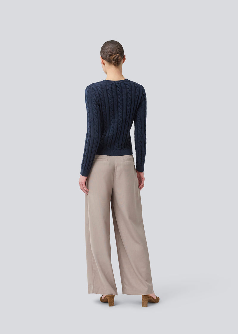 Fitted knit with a round neckline in 100% organic cotton. Sabremd o-neck has a cable pattern and an embroidered chest logo. The model is 175 cm and wears a size s/36.