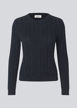 Fitted knit with a round neckline in 100% organic cotton. Sabremd o-neck has a cable pattern and an embroidered chest logo. The model is 175 cm and wears a size s/36.