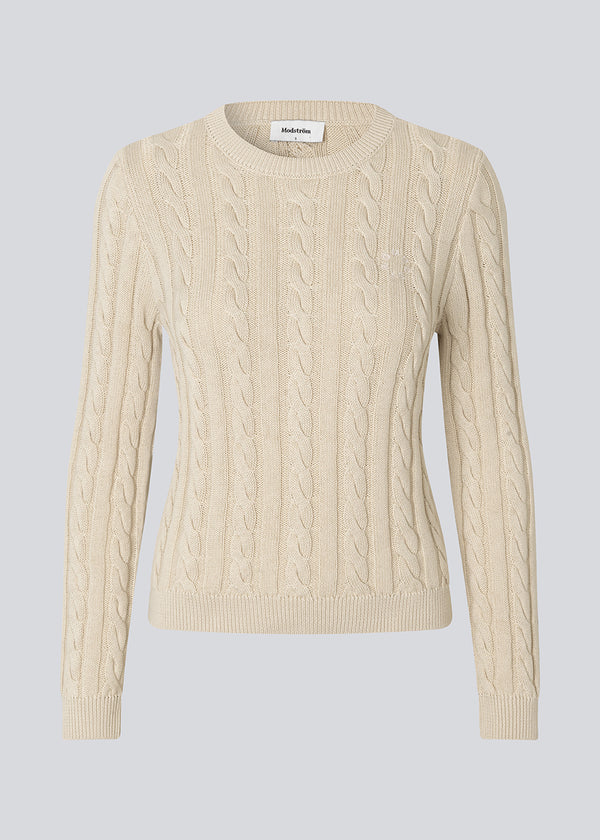 Fitted knit with a round neckline in 100% organic cotton. Sabremd o-neck has a cable pattern and an embroidered chest logo. The model is 175 cm and wears a size s/36.