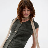 Elegant knitted vest in dark green with a round neckline and decorative buttons at the front. The Scottmd vest is designed in structured knit with ribbed edges, giving a modern and feminine look. Perfect worn on its own or styled over a shirt for a sophisticated layered outfit.
