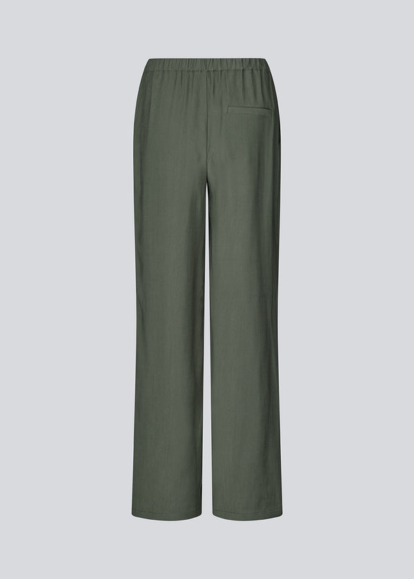 Loose everyday trousers in mos green. Sebastianmd pants have an elastic waist for a perfect fit and a casual look that can easily be styled up with an elegant, printed shirt or top. Your new go-to trousers for both everyday and special occasions.