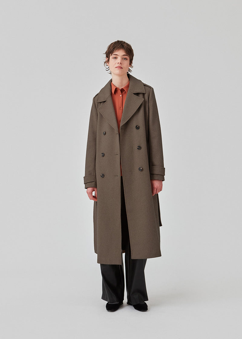 Classic, double-breasted wool coat in a brown color with collar and notch lapels. ShayMD coat has a wide tiebelt at waist, shoulder straps, wide cuffs and open yoke. With lining and single back vent.