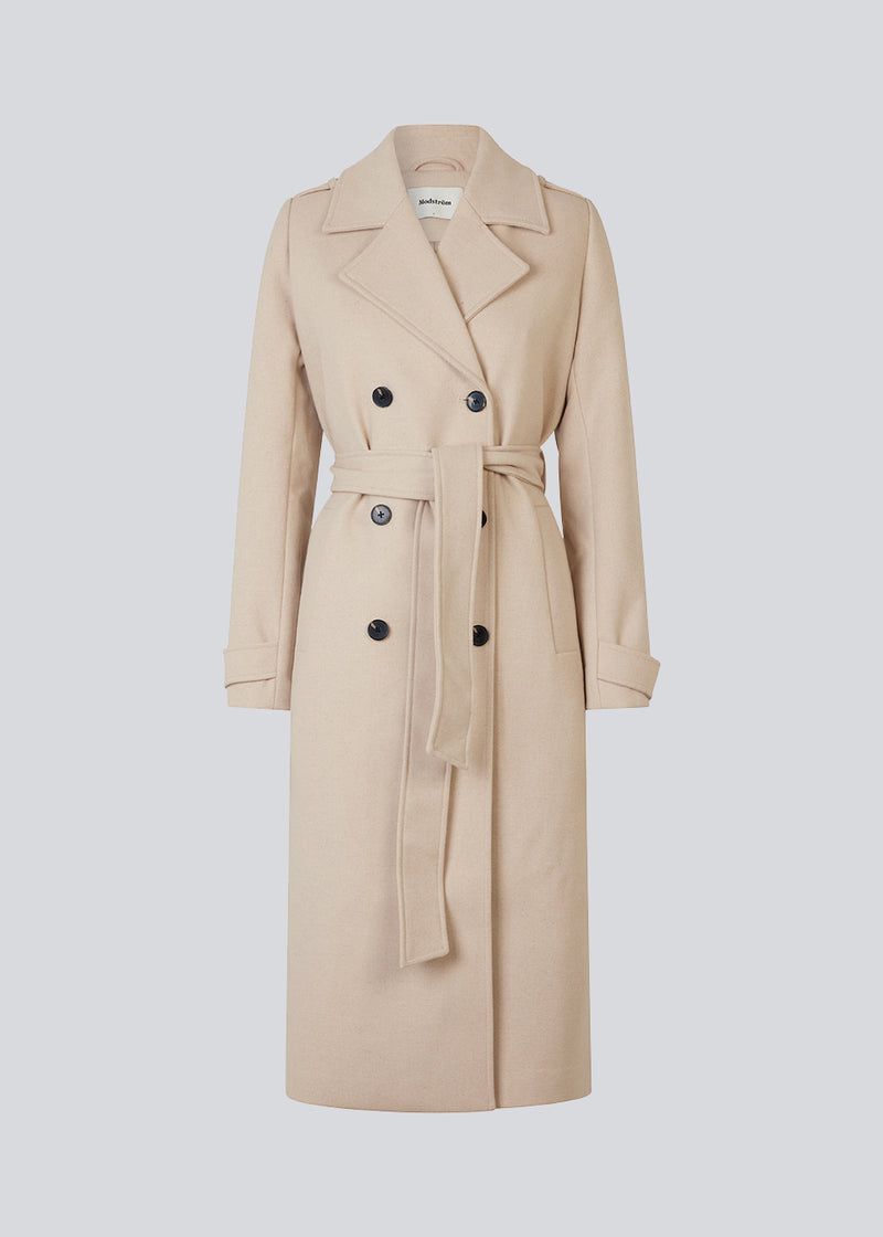 Classic, double-breasted wool coat in beige with collar and notch lapels. ShayMD coat has a wide tiebelt at waist, shoulder straps, wide cuffs and open yoke. With lining and single back vent.