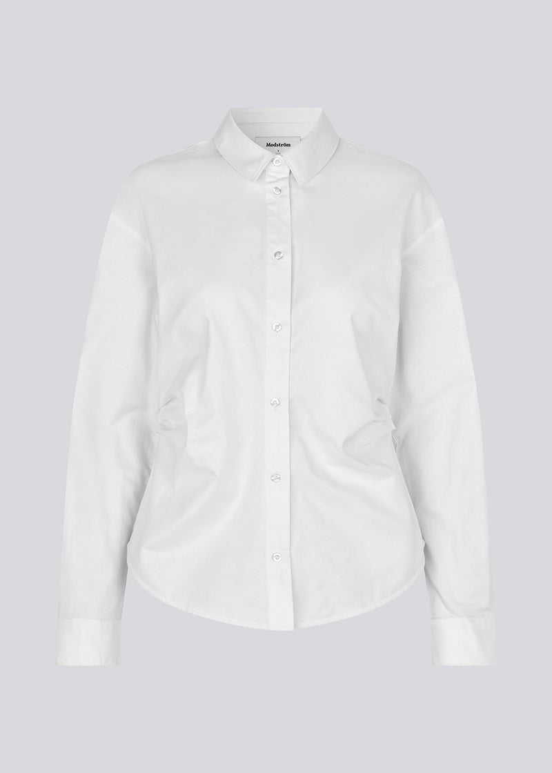 Modern white shirt with a feminine look. The Siobanmd shirt has classic details such as collar, button closure and long sleeves. Gathering at the waist creates a beautiful, feminine silhouette. Made of 58% organic cotton.