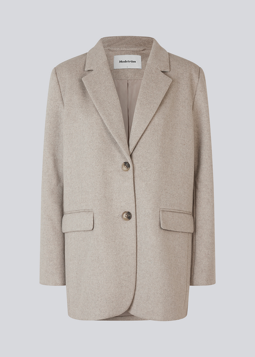 Blazer in light grey with an oversized silhouette in a wool weave. SonnyMD jacket has a collar and notch lapels with two buttons in front and flap front pockets. Slit at sleeves and vent in back. Lined.