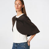 Tailormd Cape is an elegant satin cape designed to add a refined and dramatic finish to any outfit. It drapes effortlessly over the shoulders and fastens at the front with a decorative knot detail, creating a soft, fluid silhouette. Layer it over a dress for special occasions or style it with a simple top for an elevated, sophisticated look. The model is 175 cm tall and is wearing a size S/36.