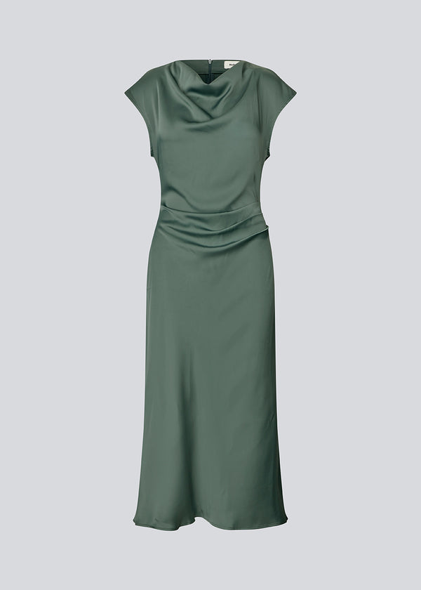 Sleeveless maxi dress in beautiful green with pleats on the side. TailorMD dress is made in satin and has a high neck, an invisible zipper in the back, and a slit in the side seam. The model is 177 cm and wears a size s/36.
