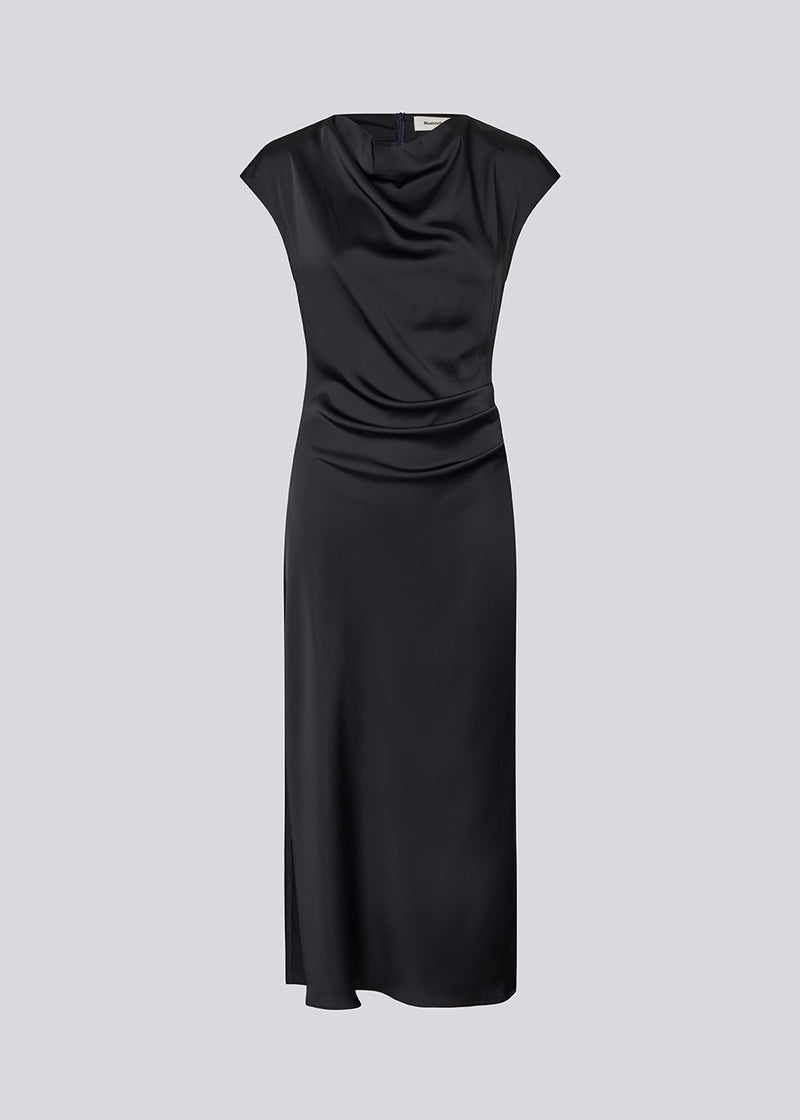 Dark blue Sleeveless maxi dress with pleats in the side. TailorMD dress is made in satin and has a high neck, invisible zipper in the back and a slit in the side seam.