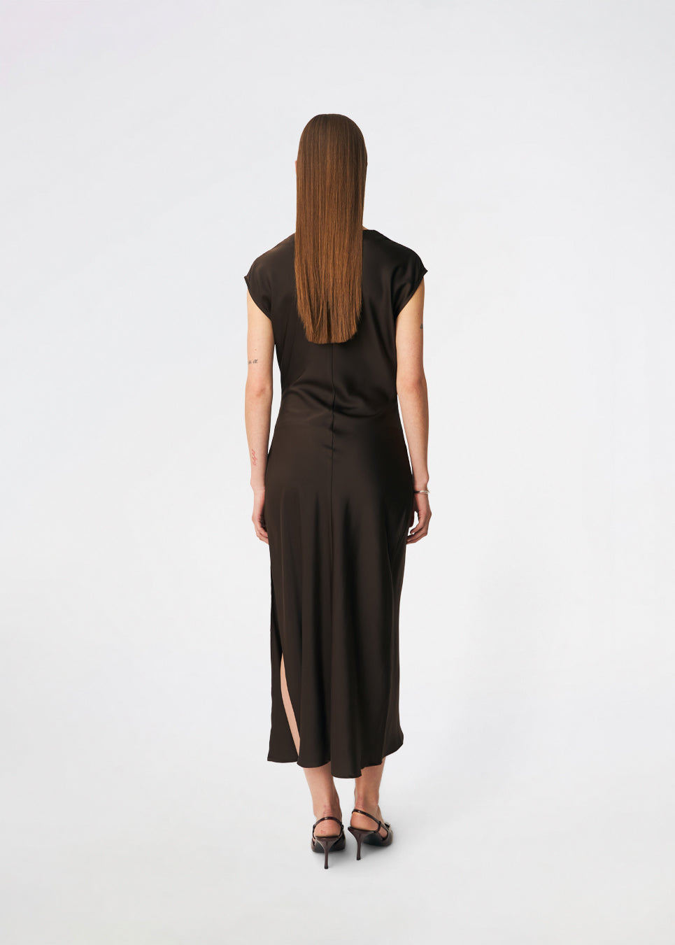 Sleeveless maxi dress with pleats in the side. TailorMD dress is made in satin and has a high neck, invisible zipper in the back and a slit in the side seam. The model is 175 cm and wears a size s/36.