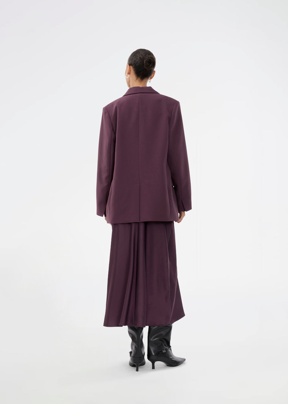 Purple sleeveless maxi dress with pleats in the side. TailorMD dress is made in satin and has a high neck, invisible zipper in the back and a slit in the side seam. The model is 175 cm and wears a size s/36.