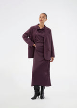Purple sleeveless maxi dress with pleats in the side. TailorMD dress is made in satin and has a high neck, invisible zipper in the back and a slit in the side seam. The model is 175 cm and wears a size s/36.