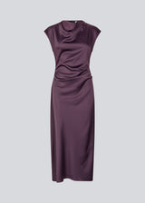 Purple sleeveless maxi dress with pleats in the side. TailorMD dress is made in satin and has a high neck, invisible zipper in the back and a slit in the side seam. The model is 175 cm and wears a size s/36.