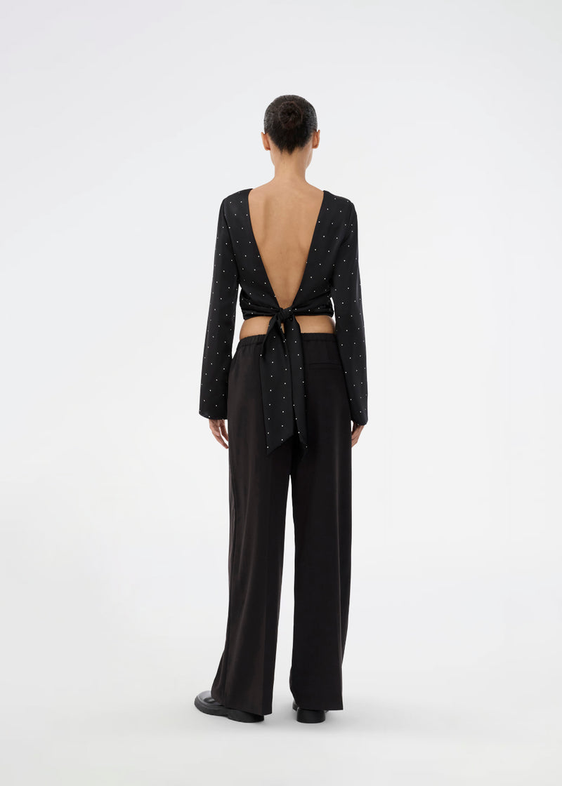 Long-sleeved satin top in black with white small dots. The TailorMD print top features a flattering open back with tie closure – combining elegance with a statement print.