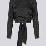 Long-sleeved satin top in black with white small dots. The TailorMD print top features a flattering open back with tie closure – combining elegance with a statement print.