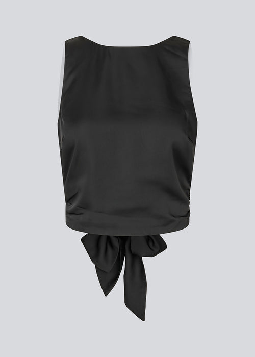 Sleeveless black top in satin. TailorMD top has an open back with a tieband. The model is 177 cm and wears a size S/36.