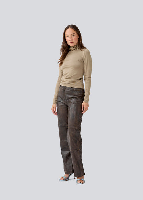 Nice brown high-necked knit in a tight fit, which is perfect for any occasion. The model is 173 cm and wears a size S/36
