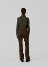 Nice pants with flared legs and front pockets. In dark green. The stretchy material and elastic waist create the perfect fit. The model is 174 cm and wears a size S/36