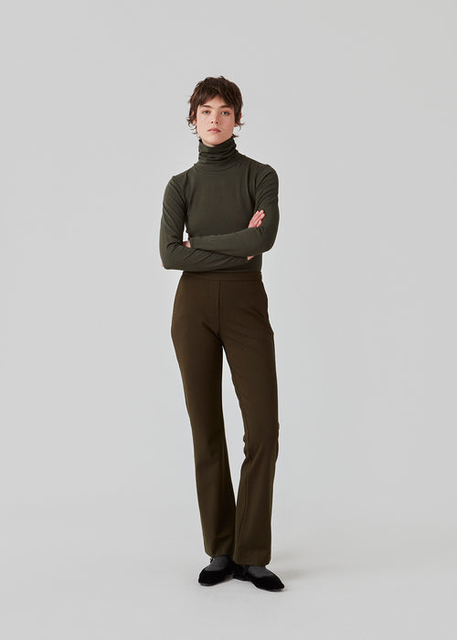 Nice pants with flared legs and front pockets. In dark green. The stretchy material and elastic waist create the perfect fit. The model is 174 cm and wears a size S/36
