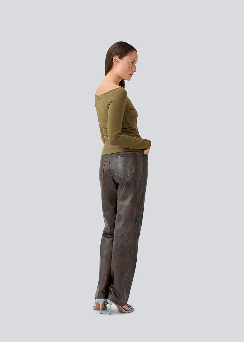 Tansy LS top is in a green color and has a simple expression with a wide neckline and long, slim sleeves. The top has a tight-fitted silhouette. The model is 173 cm and wears a size S/36.