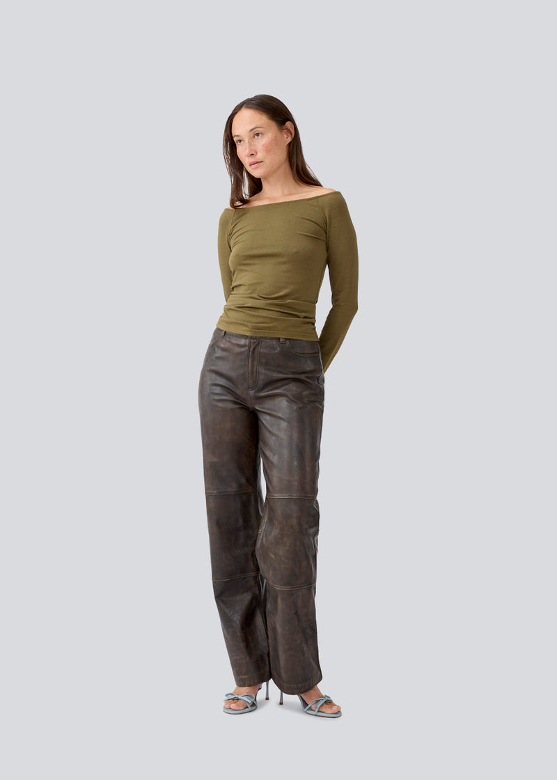 Tansy LS top is in a green color and has a simple expression with a wide neckline and long, slim sleeves. The top has a tight-fitted silhouette. The model is 173 cm and wears a size S/36.