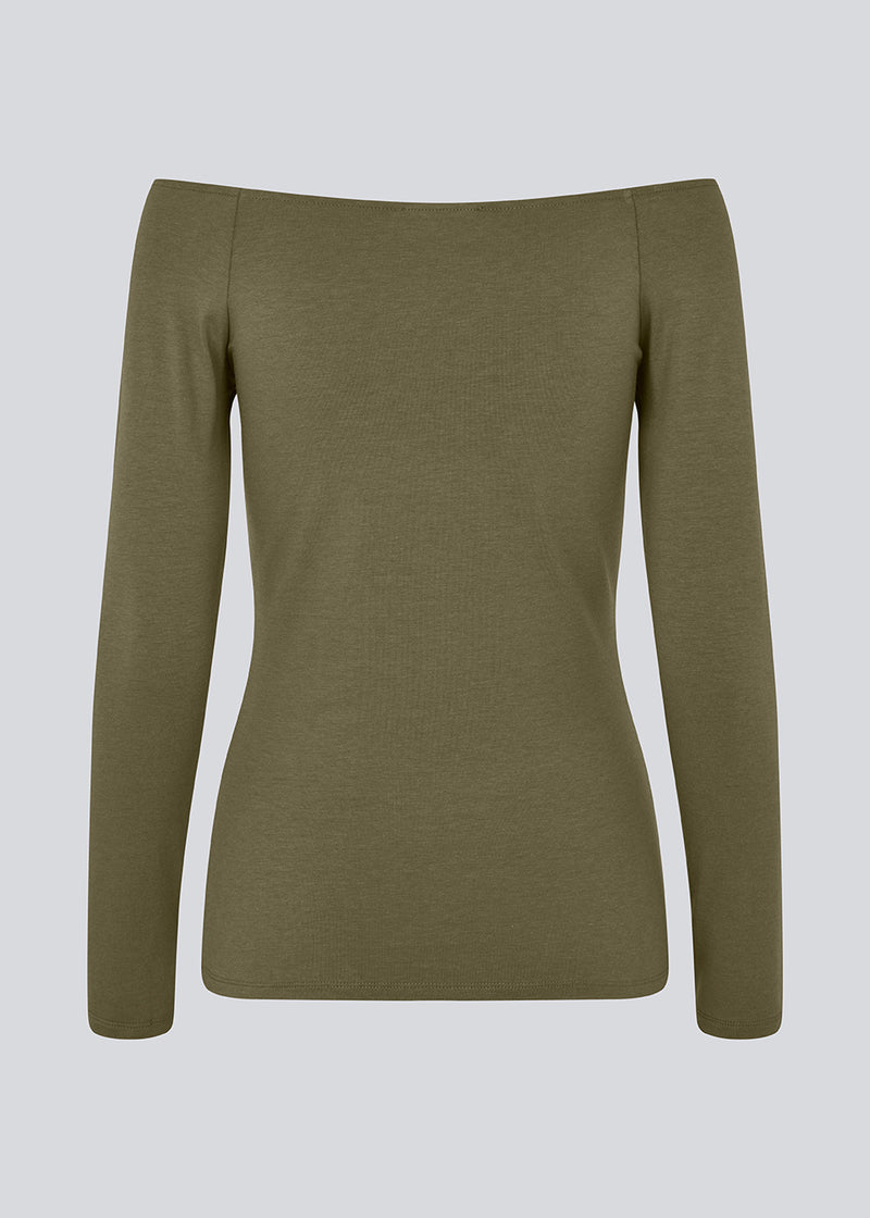 Tansy LS top is in a green color and has a simple expression with a wide neckline and long, slim sleeves. The top has a tight-fitted silhouette. The model is 173 cm and wears a size S/36.