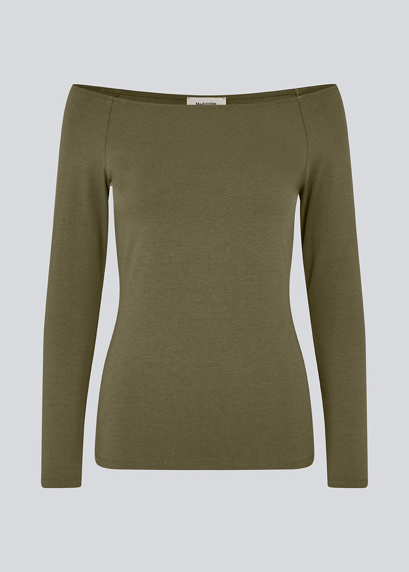 Tansy LS top is in a green color and has a simple expression with a wide neckline and long, slim sleeves. The top has a tight-fitted silhouette. The model is 173 cm and wears a size S/36.
