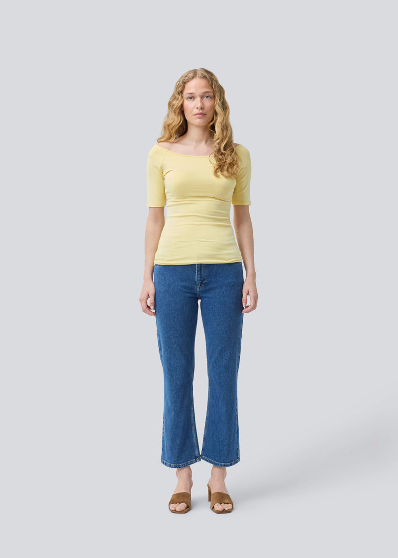 Tansy top in yellow has a simple look with a wide neckline at front and back and narrow sleeves. The top is slim fit without being tight. The model is 174 cm and wears a size S/36