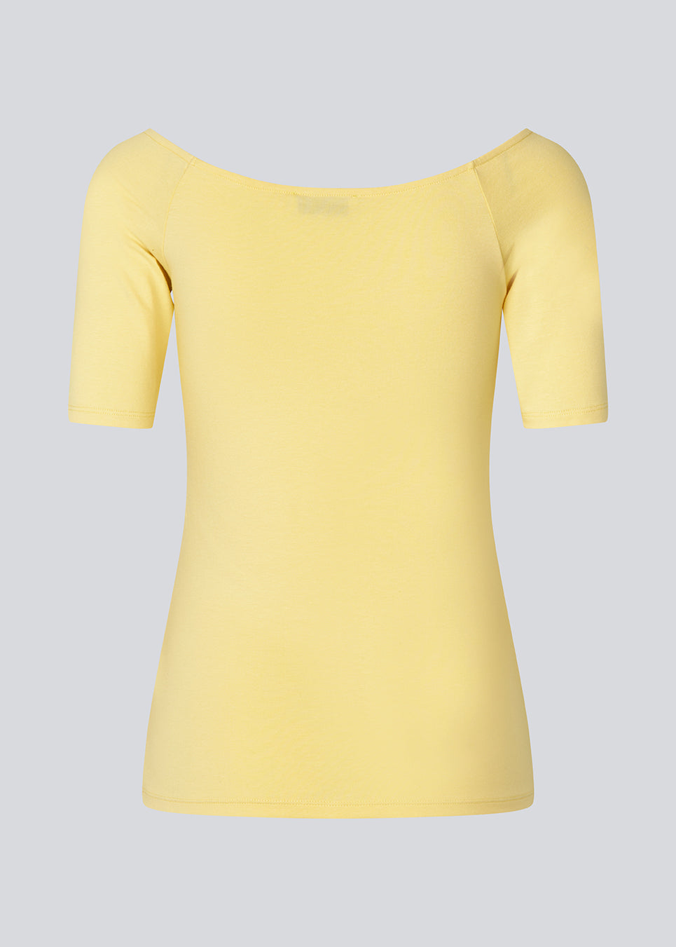 Tansy top in yellow has a simple look with a wide neckline at front and back and narrow sleeves. The top is slim fit without being tight. The model is 174 cm and wears a size S/36