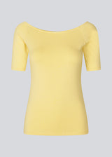 Tansy top in yellow has a simple look with a wide neckline at front and back and narrow sleeves. The top is slim fit without being tight. The model is 174 cm and wears a size S/36