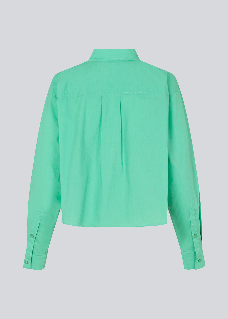 Airy shirt in the color Calm Jade in organic cotton poplin. TapirMD shirt has a collar and buttons in front, with an open chest pocket. Dropped shoulders and long sleeves with cuff and button. Embroidered logo in front.
