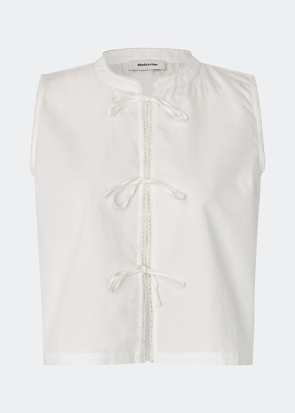 Sleeveless top crafted from a soft cotton quality. Tessamd top features tie-front closures, delicate trim details, and a clean, relaxed silhouette. A lightweight and versatile style that combines feminine details with a modern, minimalist look.