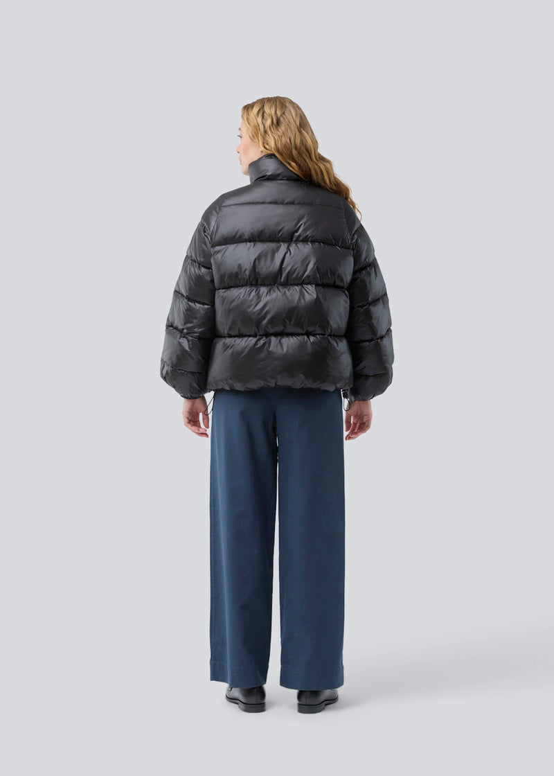 Puffer jacket with a high neck in 100% recycled polyester. Tetrismd jacket has a zipper closure and an adjustable strap at the sleeve. 