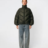Puffer jacket with a high neck in 100% recycled polyester. Tetrismd jacket has a zipper closure and an adjustable strap at the sleeve. The model is 175 cm and wears a size s/36.