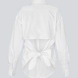 Fitted white shirt with an open back with a tiedetail. Thememd shirt has a shirt collar and a button closure in front. The model is 175 cm and wears a size s/36.

Material:
97% Cotton
3% Elastane
