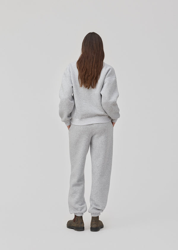 Sweatpants in grey with logo in a cotton mixture. TiaMD pants have sidepockets, tieband and an elastic in the bottom and waist.