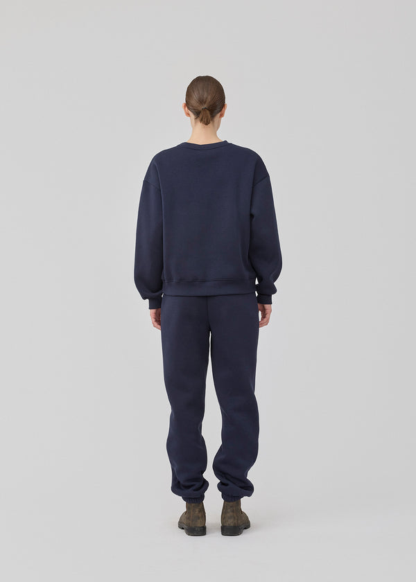 Sweatpants in navy blue with logo in a cotton mixture. TiaMD pants have side pockets, a tieband and an elastic in the bottom and waist.
