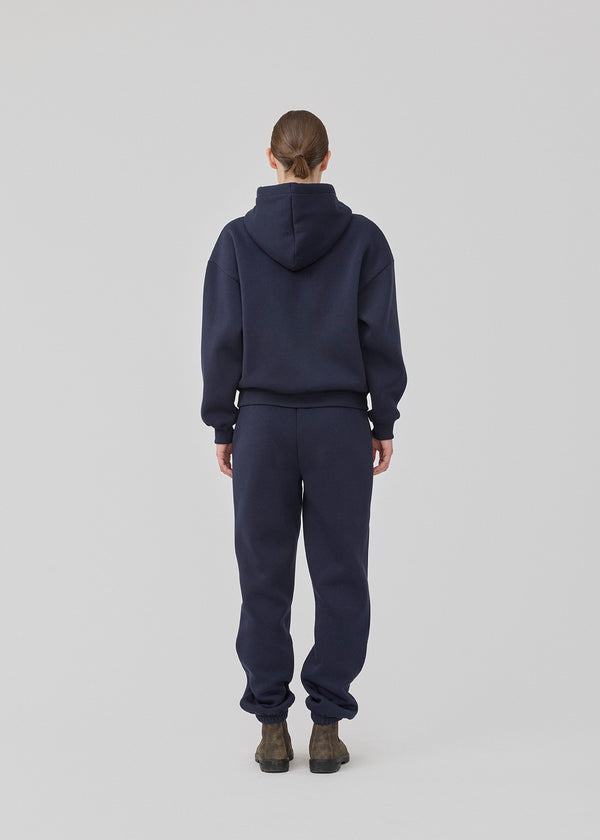 <p>Sweatshirt in navy blue with a zipper and logo in a cotton mixture. TiaMD Zip has pockets, ribbing at the sleeves and bottom, and a hood with strings.</p> <p><a href="https://modstrom.com/products/tiamd-pants-navy-sky" title="tiamd-pants-navy-sky">Style with matching pants.</a></p>